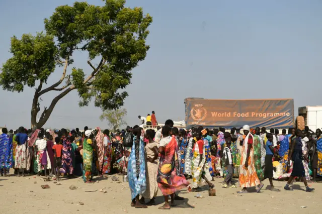 nternally displaced women wait for their food ration during a food distribution next to a World Food Programme (WFP) truck in Bentiu on February 7, 2023.