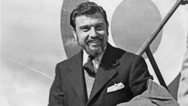 George Blake wearing a suit getting off an aircraft