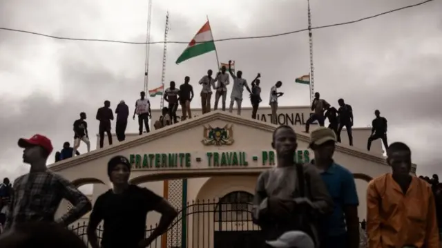 Protesters hold a Niger flag during a demonstration on independence day in Niamey on August 3, 2023. Hundreds of people backing the coup in Niger gathered on August 3, 2023 for a mass rally in the capital Niamey with some brandishing giant Russian flags.