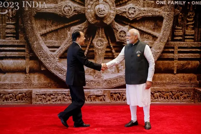 Prime Minister Narendra Modi (R) shakes hand with Chinese Foreign Minister Wang Yi at the Bharat Mandapam