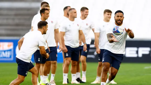 Manu Tuilagi catches a ball during an England training session