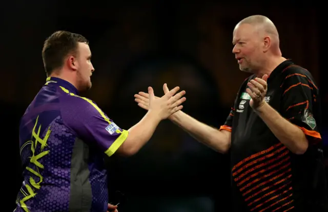 Luke Littler grabs Raymond van Barneveld's hand after his victory over the Dutchman