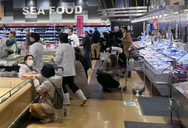 Shoppers crouch down as an earthquake hit the region at a supermarket in Toyama, Japan January 1, 2024