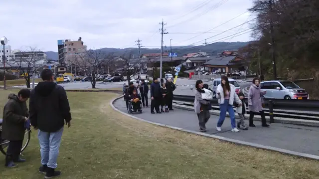 People evacuate toward higher ground after a tsunami warning caused by an earthquake