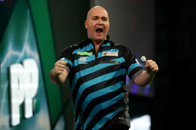 Rob Cross celebrates beating Chris Dobey