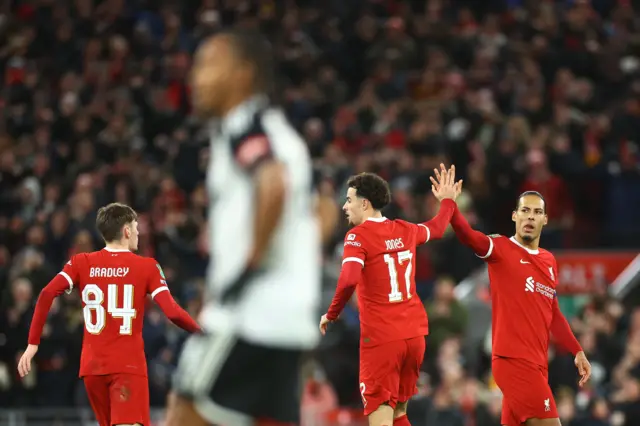 Decordova-Reid stands with his hands on his hips as Liverpool celebrate their first goal.