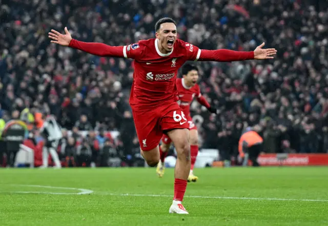 Alexander-Arnold runs to celebrate with his arms out wide after scoring a very late winner.