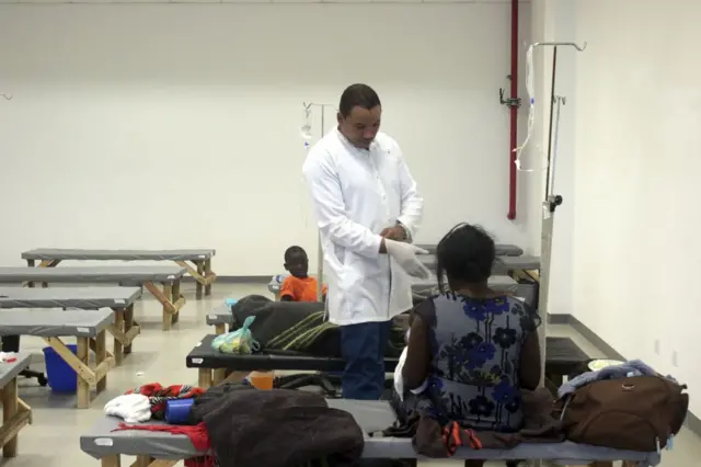 A doctor tends to a patient affected by Cholera at the Heroes stadium temporary transformed in a hospital on January 15, 2018 in Lusaka, Zambia