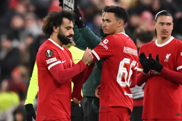 Mo Salah hands over the captain's armband to Trent Alexander-Arnold.