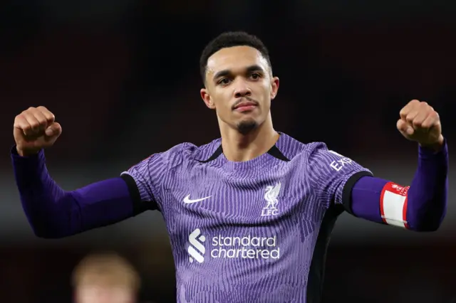 Alexander-Arnold salutes the travelling fans by raising both fists in the air.