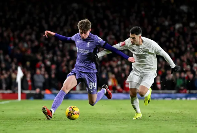 Connor Bradley runs with the ball while trying to evade a challenge from Gabriel Martinelli.