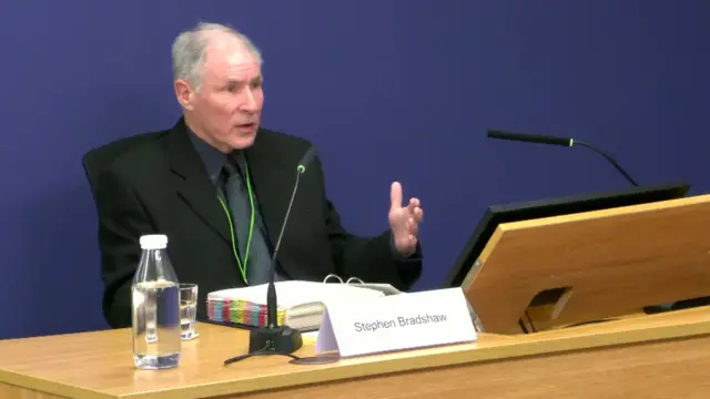 Stephen Bradshaw sitting at a desk in the Post Office inquiry room