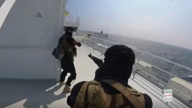 Armed men dropping from a helicopter and seizing a cargo ship