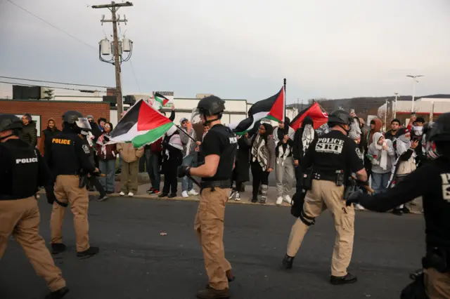 Police stood in the street with demonstrators holding flags