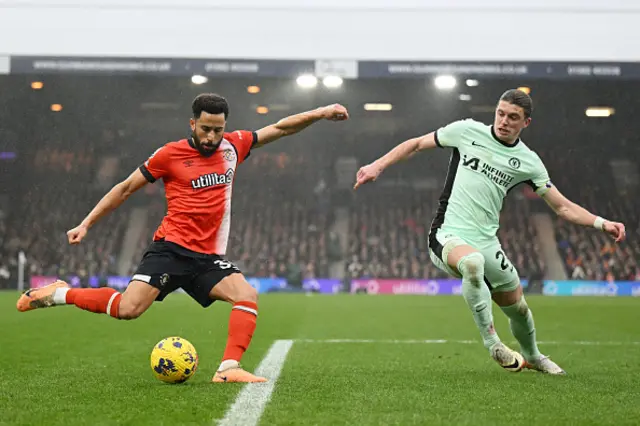 Andros Townsend of Luton Town crosses the ball whilst under pressure from Conor Gallagher