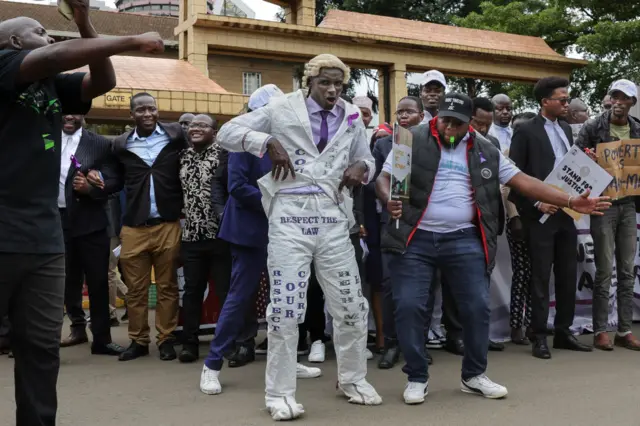 Kenyan advocates dance and gesture during a picket following a protest call to members by the Law Society of Kenya against recent remarks by Kenya's President, William Ruto