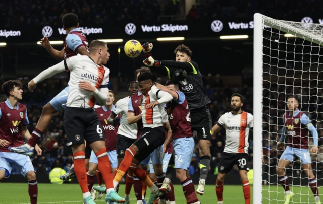 James Trafford punches the ball as a sea of players stand in his way