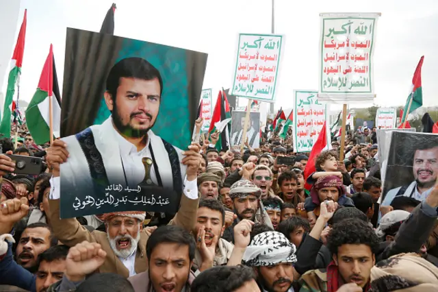 Demonstrators lift posters of Abdul-Malik Badreddin al-Houthi during a protest staged in solidarity with Gaza in Sana'a - 29 December 2023