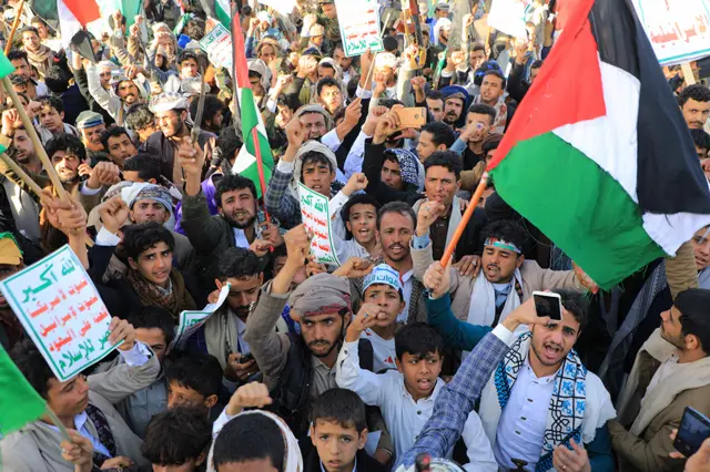 Yemeni demonstrators, some with Palestinian flags, shout slogans during a protest following US and British forces strikes, in the Huthi-controlled capital Sanaa on January 12, 2024