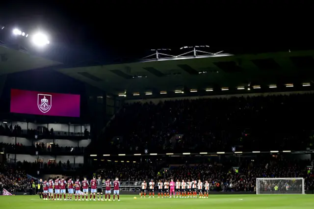 Both teams applaud while standing on the pitch