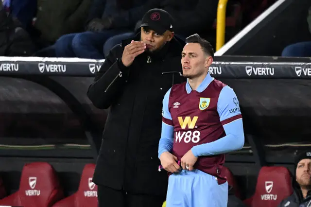 Vincent Kompany (L) speaks with Burnley's Welsh defender