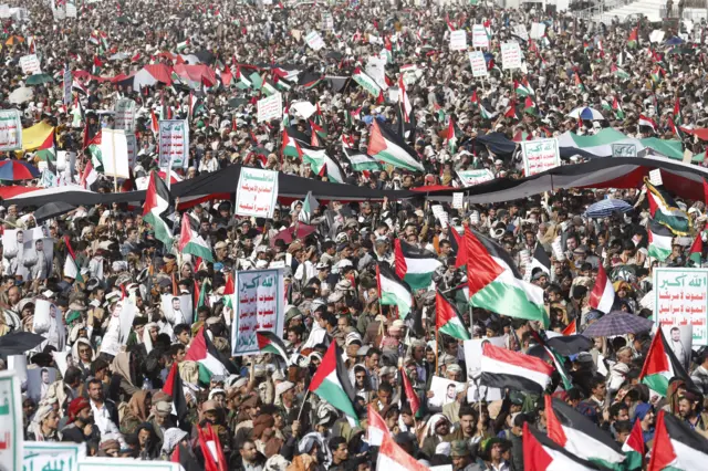 Thousands of people holding flags