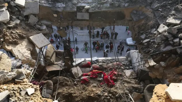 Palestinians gather at the site of an Israeli strike in Rafah