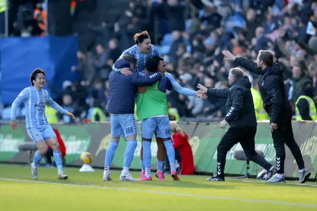 Coventry players and coaching staff  celebrate a goal against Leicester