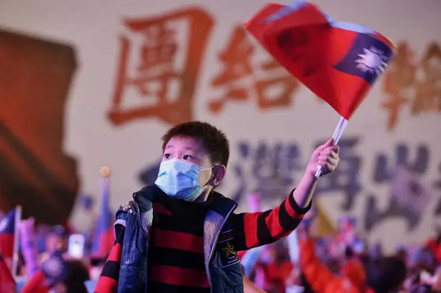 A child holds Taiwan's national flag during an election campaign rally for the Kuomintang