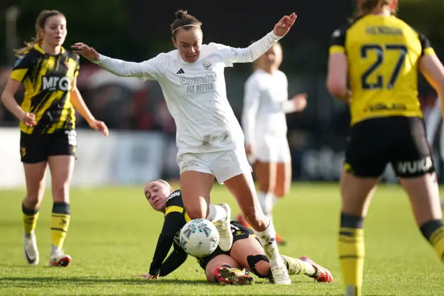 Caitlin Foord is challenged from behind as she looks to break downfield with the ball.