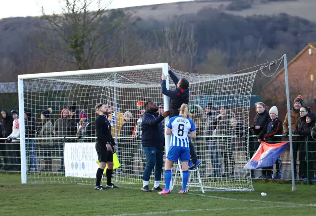 A man fixes the net in the Women's FA Cup tie between Luton and Brighton