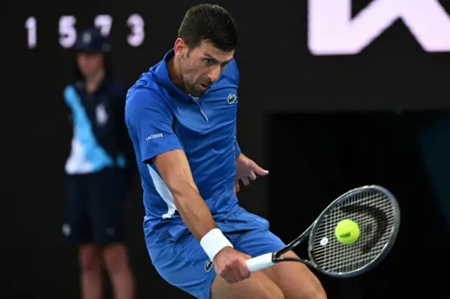 Novak Djokovic hits a low backhand shot