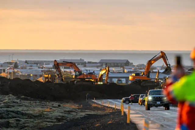 Emergency personell use diggers to fill in the last whole in a protective wall to try to prevent the lava from reaching Grindavik