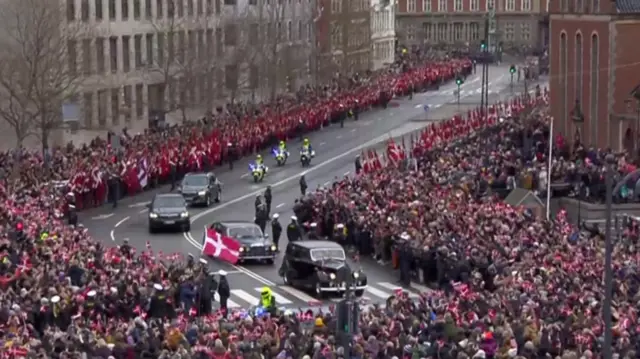 The car carrying the royal family passes crowds