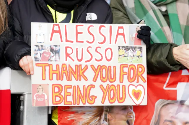 A fan holds up a poster for Alessia Russo