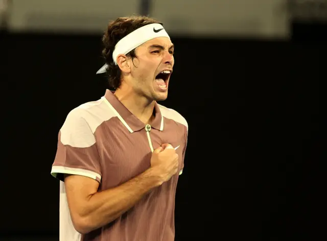 Taylor Fritz roars and pumps his fist on his heart in celebration.