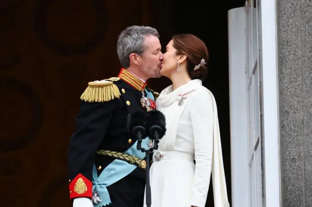 King and Queen kiss on balcony