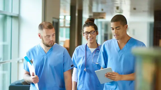 Three junior doctors walking in a hospital