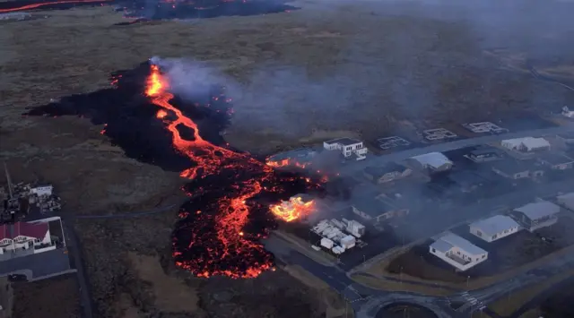 Lava flows from a volcano as houses burn in Grindavik