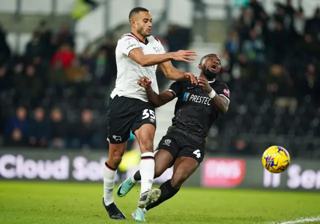 Derby County's Curtis Nelson (left) hold off Burton Albion's Deji Oshilaja