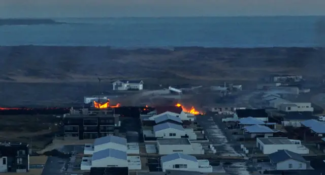 Lava explosions and billowing smoke are seen near homes in the town of Grindavik