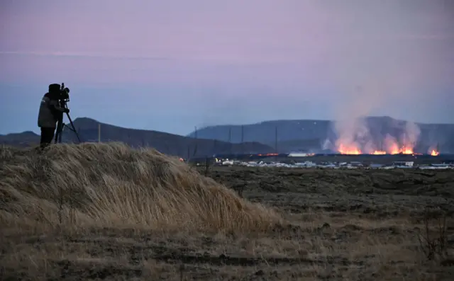 A photographer takes a picture of Grindavik from a nearby hill