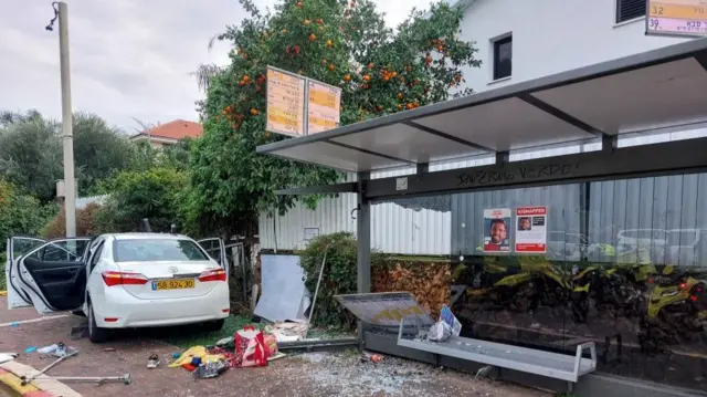 The scene of a damaged car at a bus station following a suspected ramming attack in Raanana