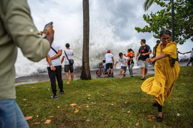 People try to evade waves crashing to shore amid Cyclone Belal, in Saint-Denis on Reunion Island