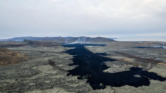 An aerial image of Grindavik where lava can be seen near houses