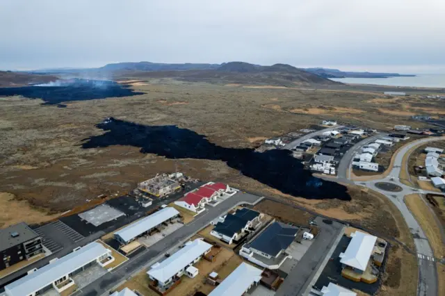 An aerial image of Grindavik where lava can be seen near houses