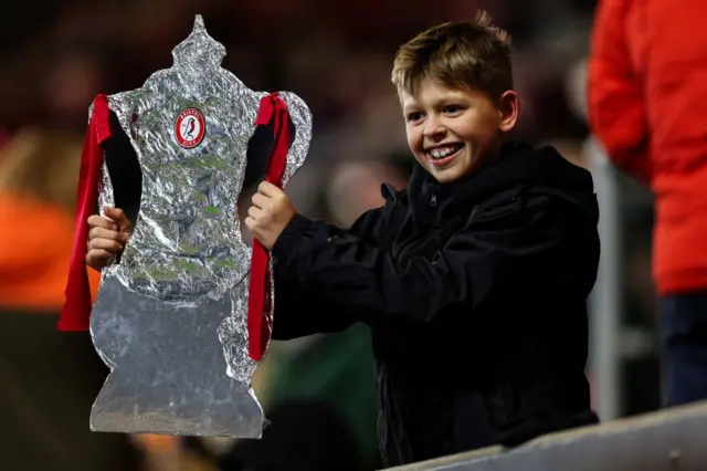 A Bristol City fan holding a foil FA Cup trophy