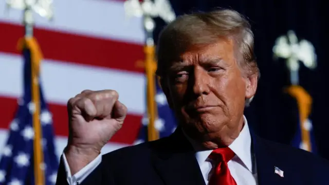 Donald Trump pumps his fist after victory in the Iowa caucuses