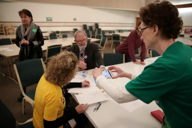 A precinct worker documents the process