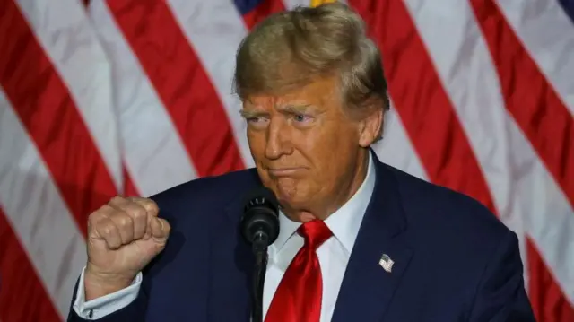 Donald Trump gestures during his caucus night watch party in Des Moines